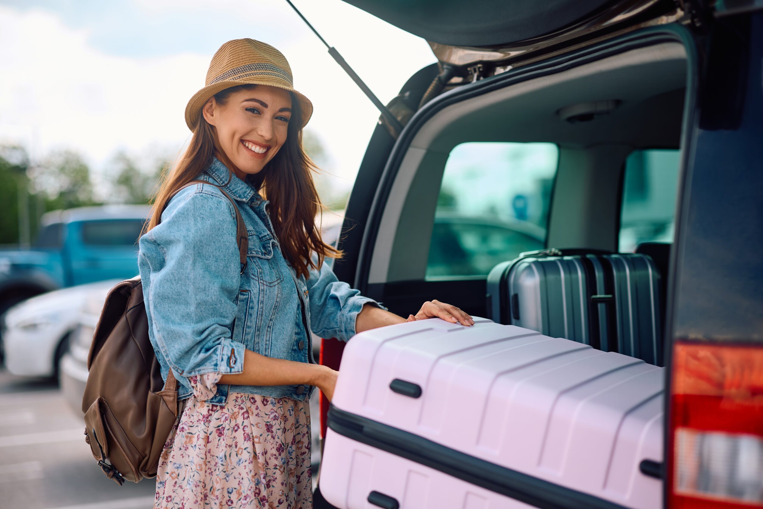 Happy,Woman,Taking,Her,Travel,Bag,Out,Of,The,Trunk